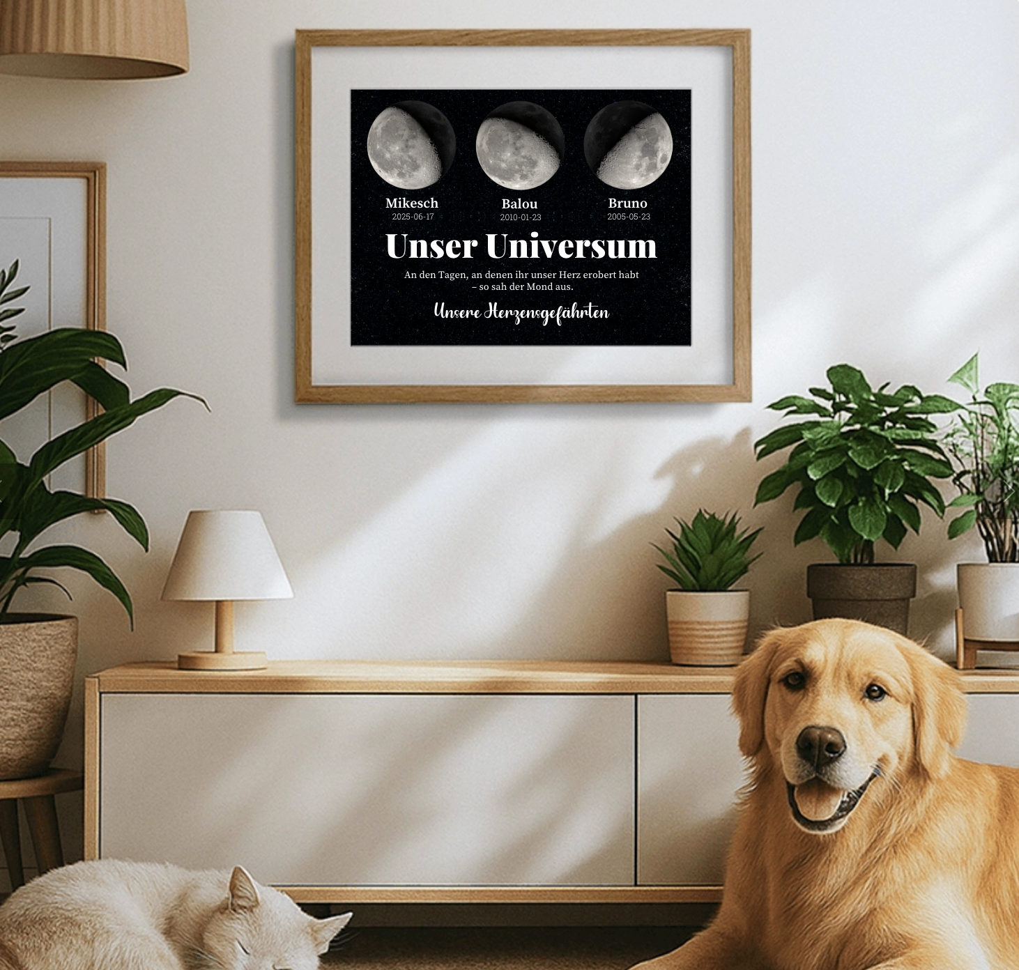 Poster mit drei Mondphasen und Namen von Haustieren, eingerahmt über Sideboard mit Hund und Katze im gemütlichen Wohnzimmer.